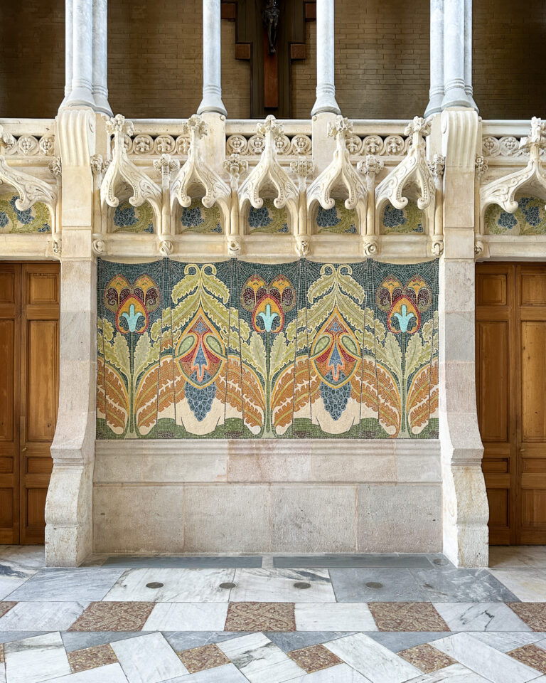 The breathtaking interior of the Recinte Modernista de Sant Pau in Barcelona, showcasing intricate Catalan Modernism architecture, vaulted ceilings, and colorful mosaics.
